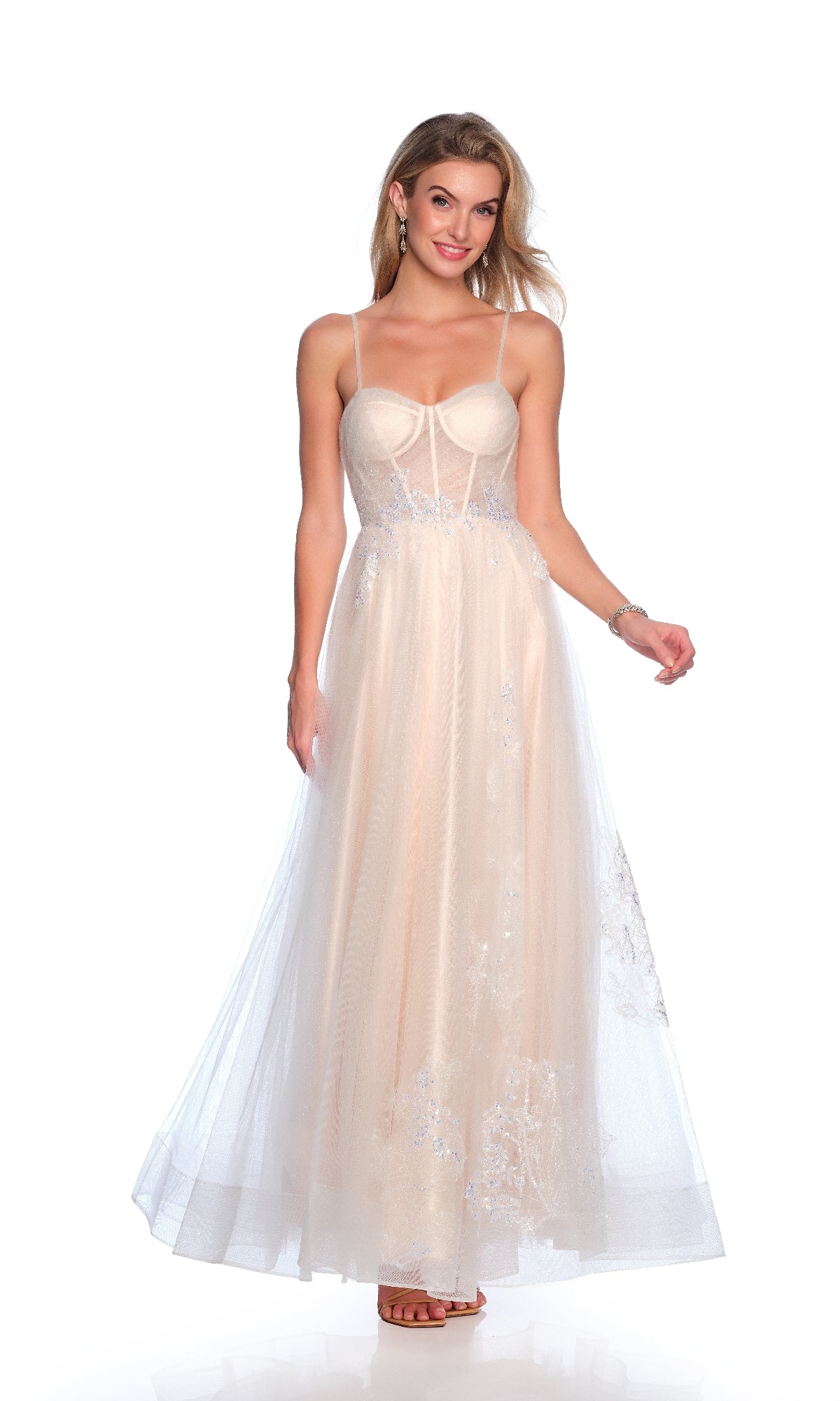 A woman poses gracefully in the Dave and Johnny 11855 long prom dress, featuring a sleeveless, sheer nude design with floral lace details, against a plain white background.